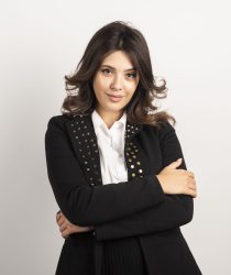 Positive woman in black jacket posing on white background. High quality photo